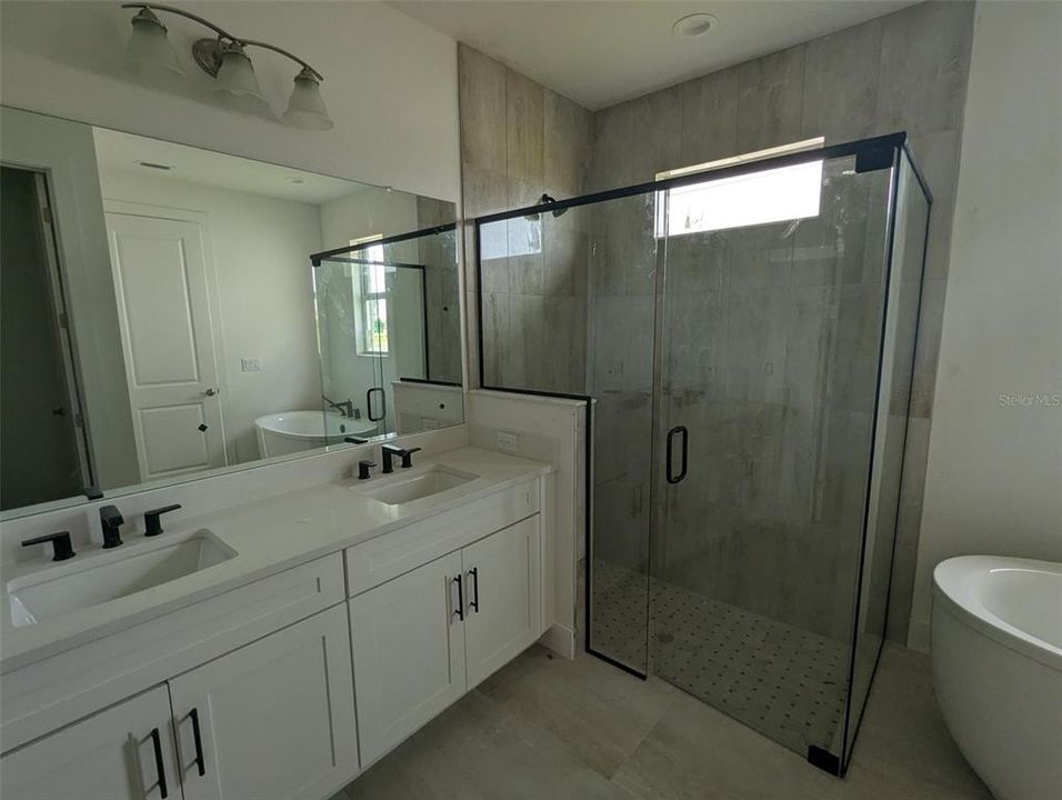 Primary bath with frameless shower and free-standing Kohler tub