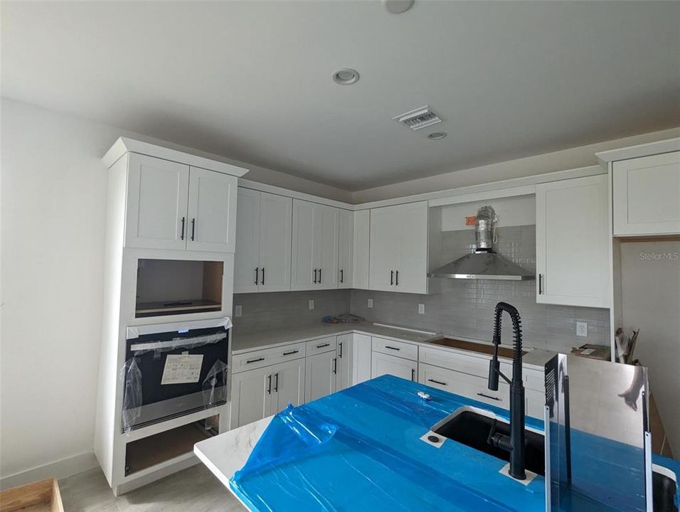 Kitchen area with wall oven and wall microwave