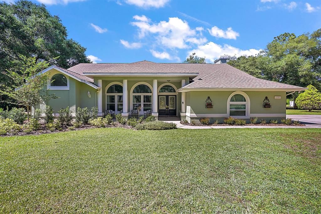 The impressive elevation and extensive landscaping create striking curb appeal