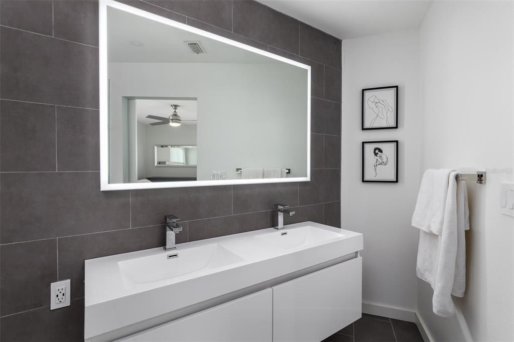 Dual sinks & an LED mirror complete the modern master bath.