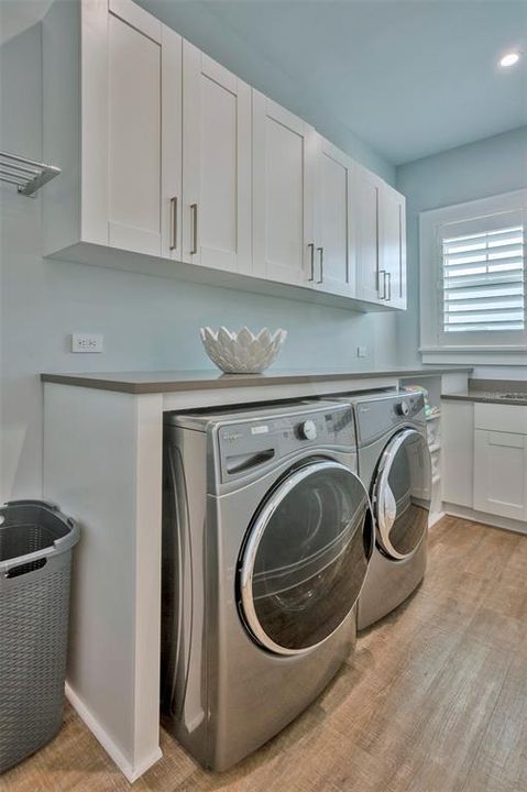 Well-equipped laundry room with beautiful cabinetry and lots of storage.
