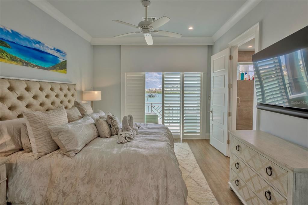 Primary bedroom with plantation shutters, solar shades and beautiful views from the balcony