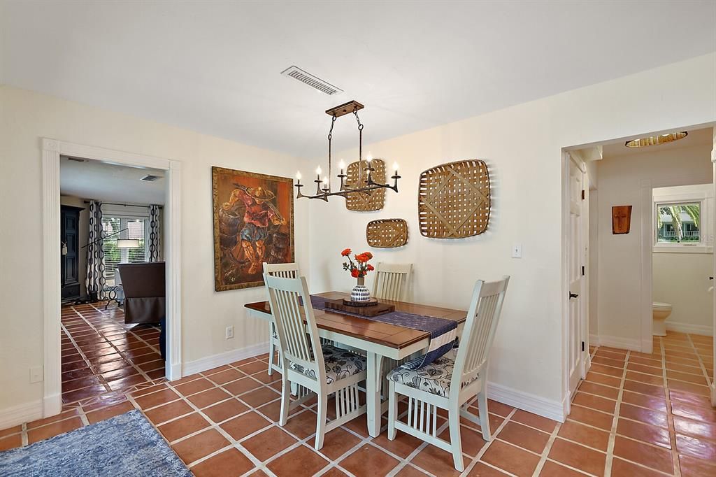 Dining room has custom lighting, with sliders to the lanai and pool