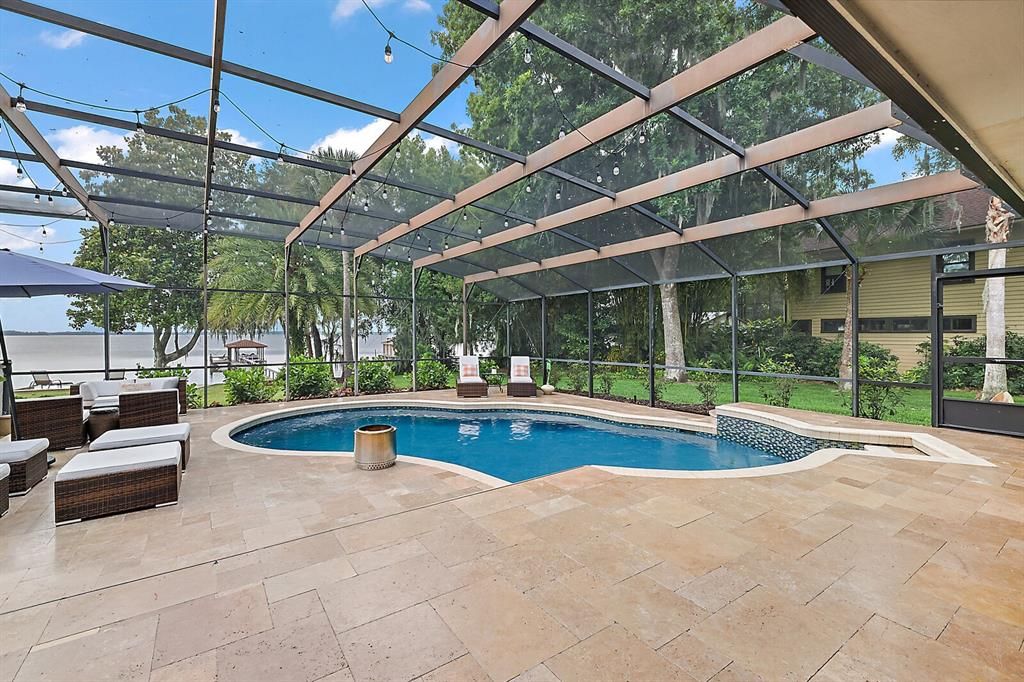 An incredible 57x45 travertine topped lanai and pool deck overlooking Lake Dora!