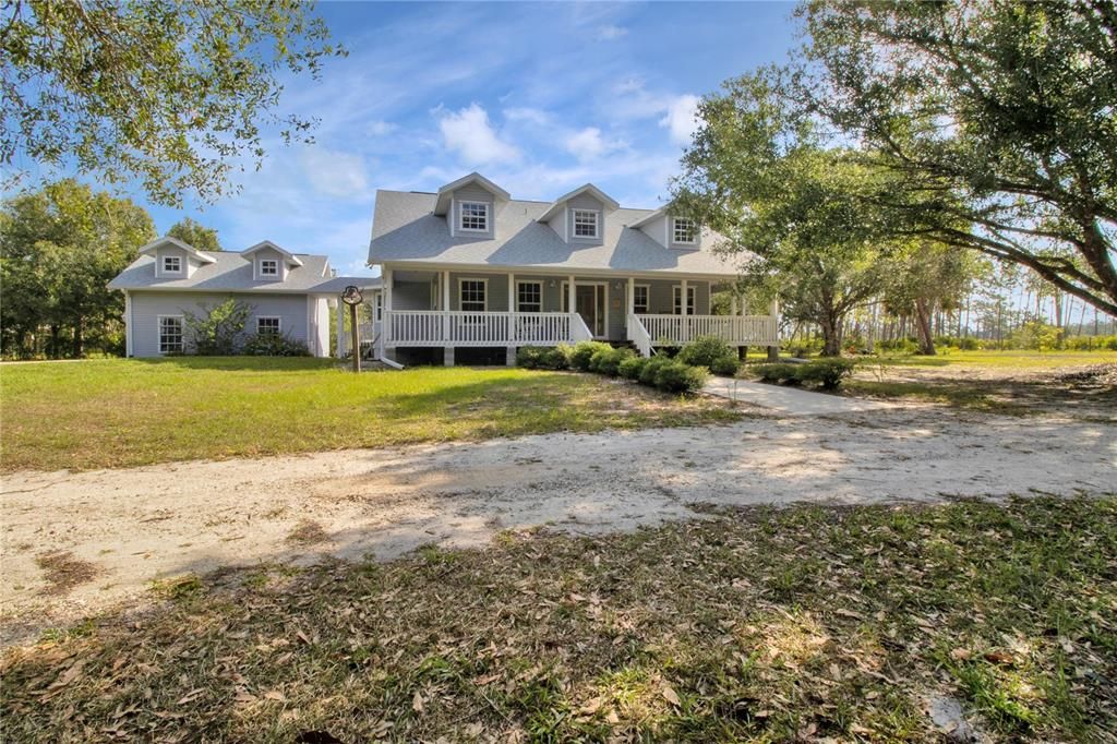 Oversized garage attached on left with covered breezeway to house