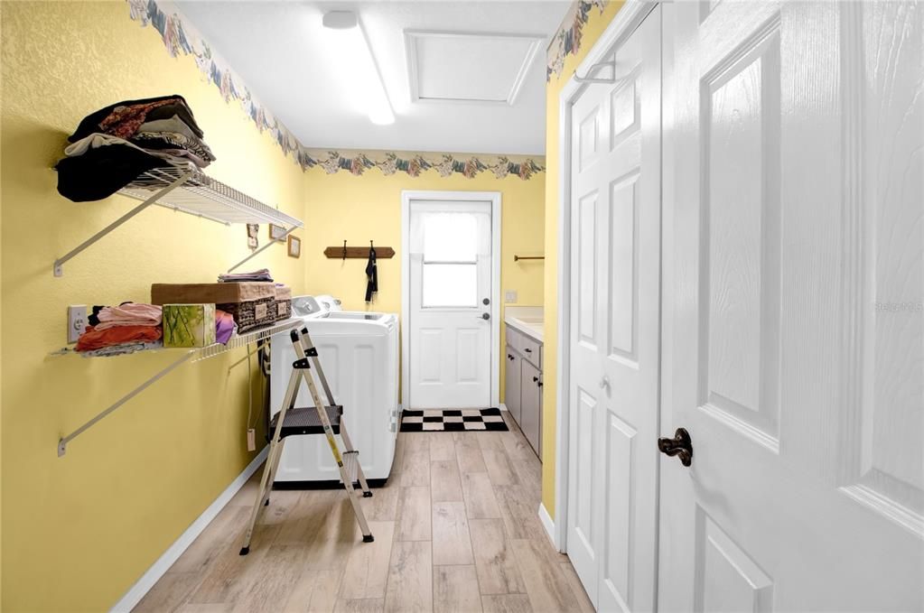 OVERSIZED LAUNDRY ROOM! Storage closet, shelves and sink! Door to outside