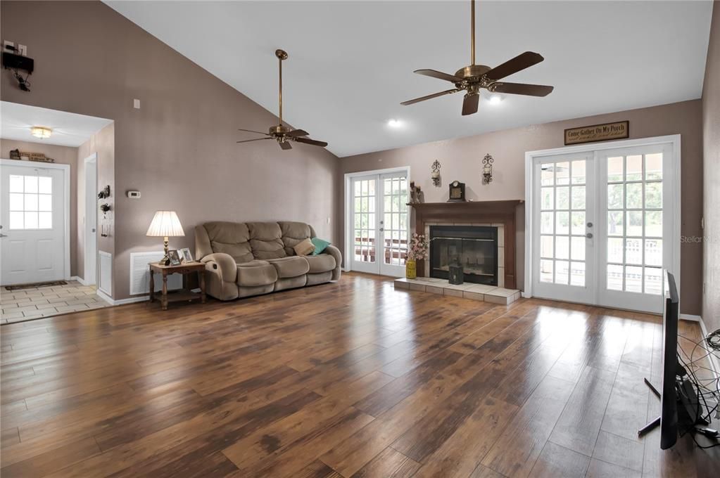 Family room, double french doors and wood burning fireplace (but has gas hook up) overlooking back porch and pool