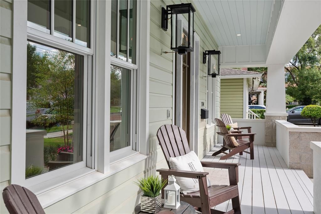Welcoming front porch highlighted with a pair of gas lanterns