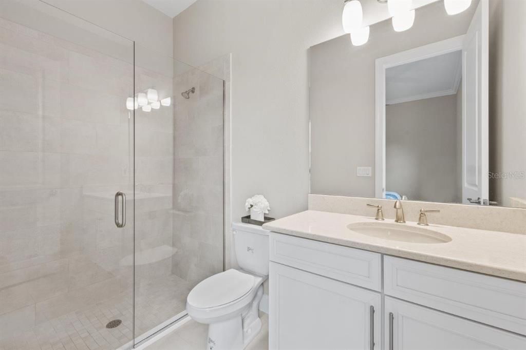 Guest suite bathroom featuring a walk-in shower and UV light exhaust fan.