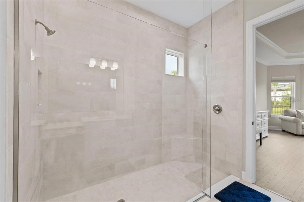 Owners Suite Bathroom featuring an extended built out closet, oversized frameless glass walk-in shower.