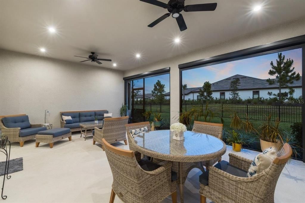 Extended covered lanai featuring custom fans, automatic sun shades, and privacy screen.