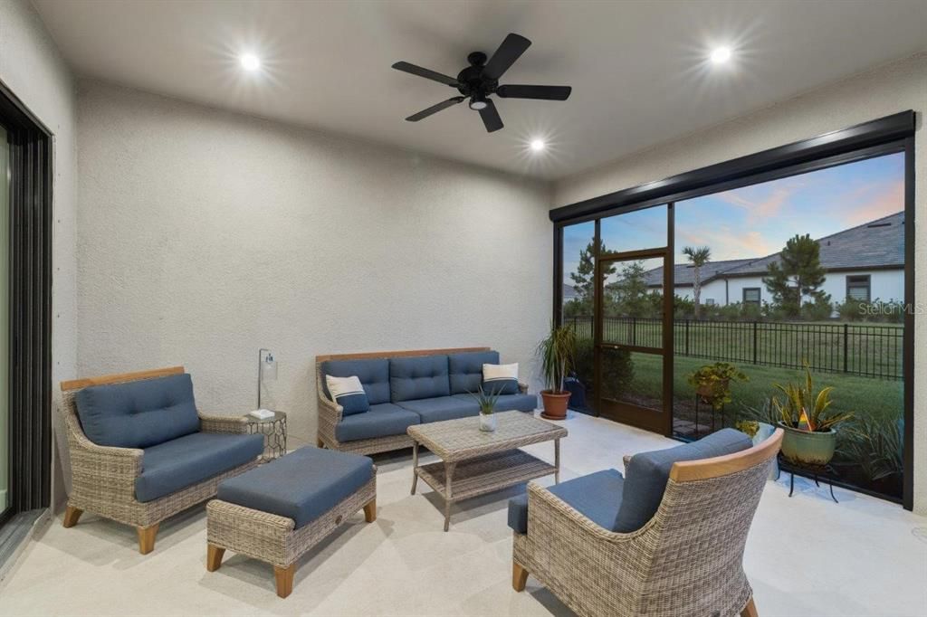 Extended covered lanai featuring custom fans, automatic sun shades, and privacy screen.