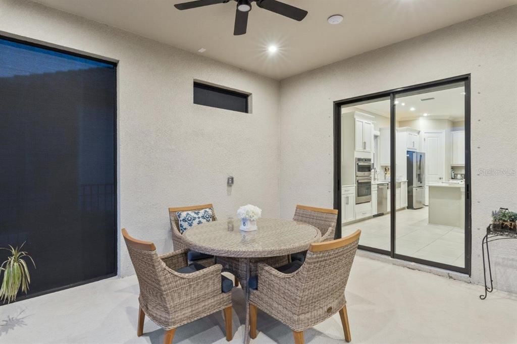 Extended covered lanai featuring custom fans, automatic sun shades, and privacy screen.