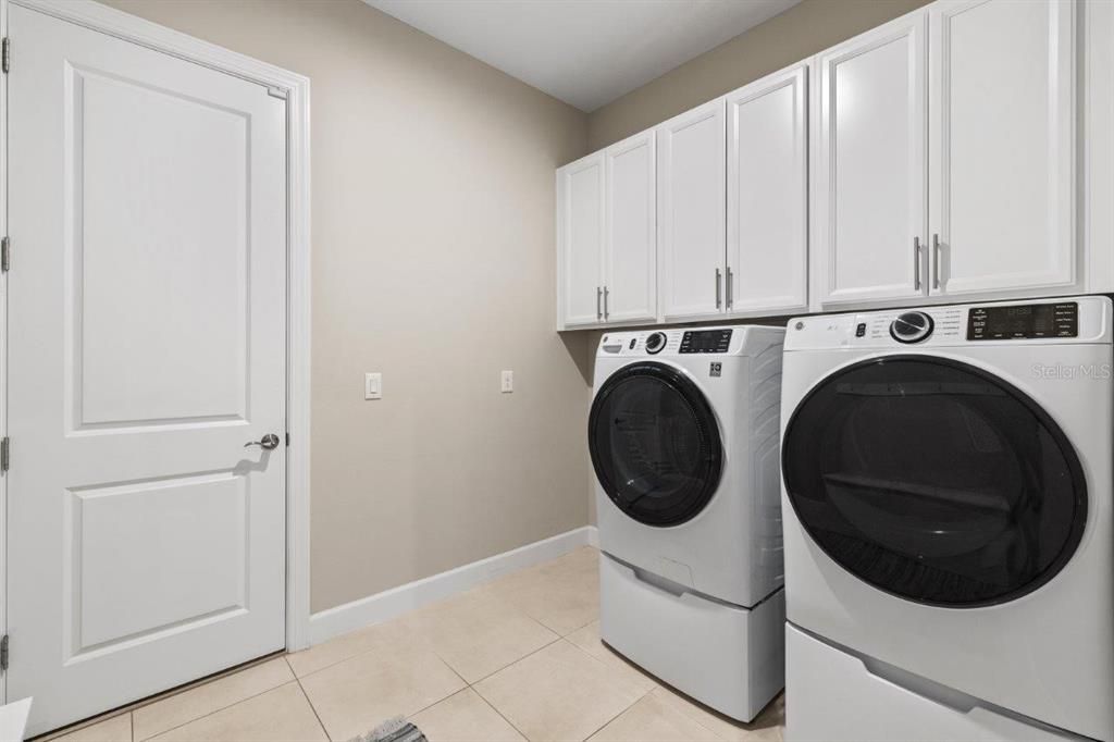 Laundry room featuring upgraded washer & dryer, and upgraded cabinetry