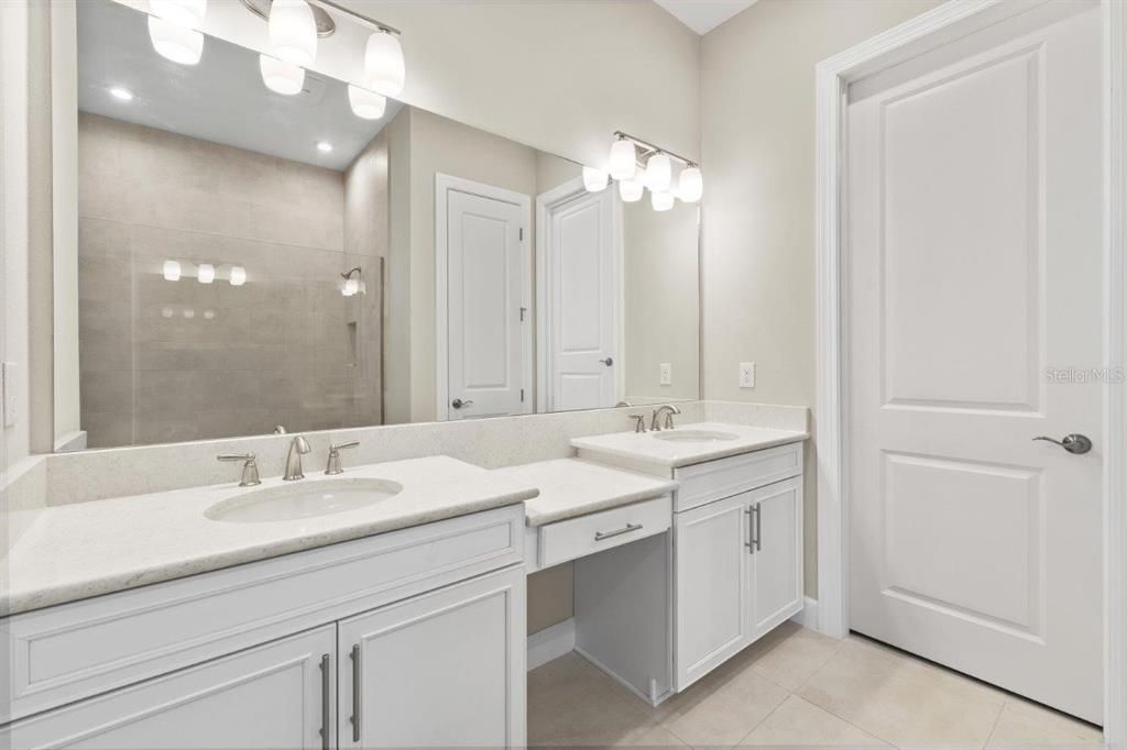 Owners Suite Bathroom featuring an extended built out closet, oversized frameless glass walk-in shower.