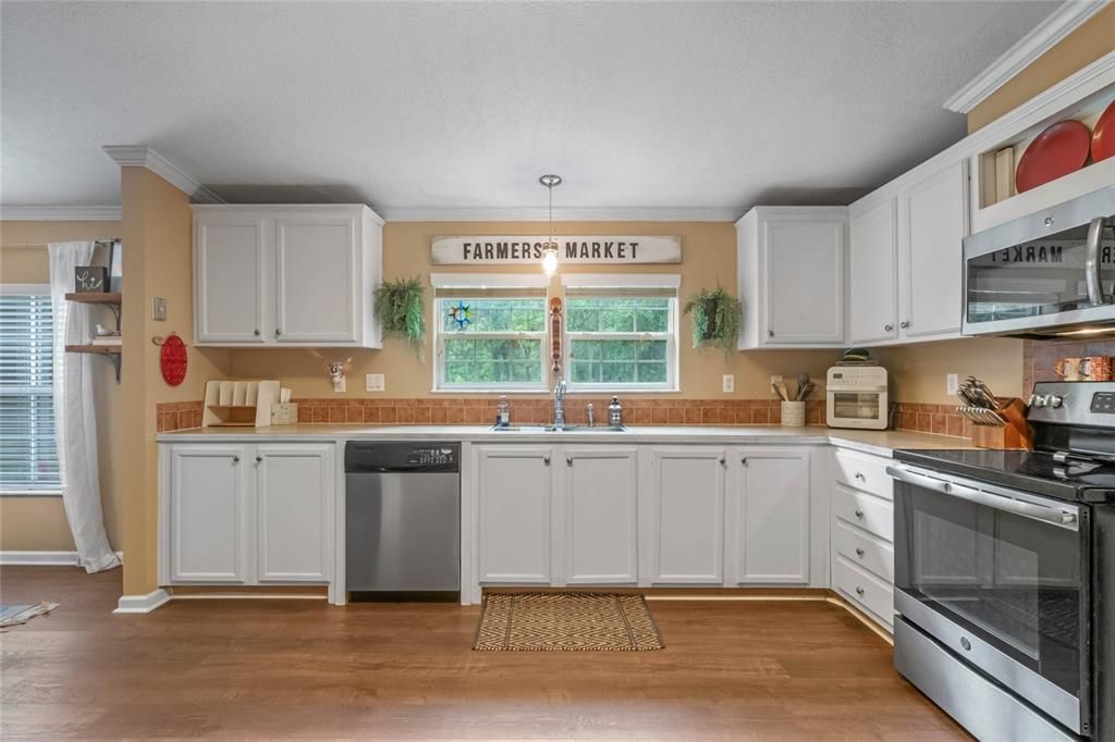Kitchen includes stainless steel appliances and windows provide a view of the front yard.