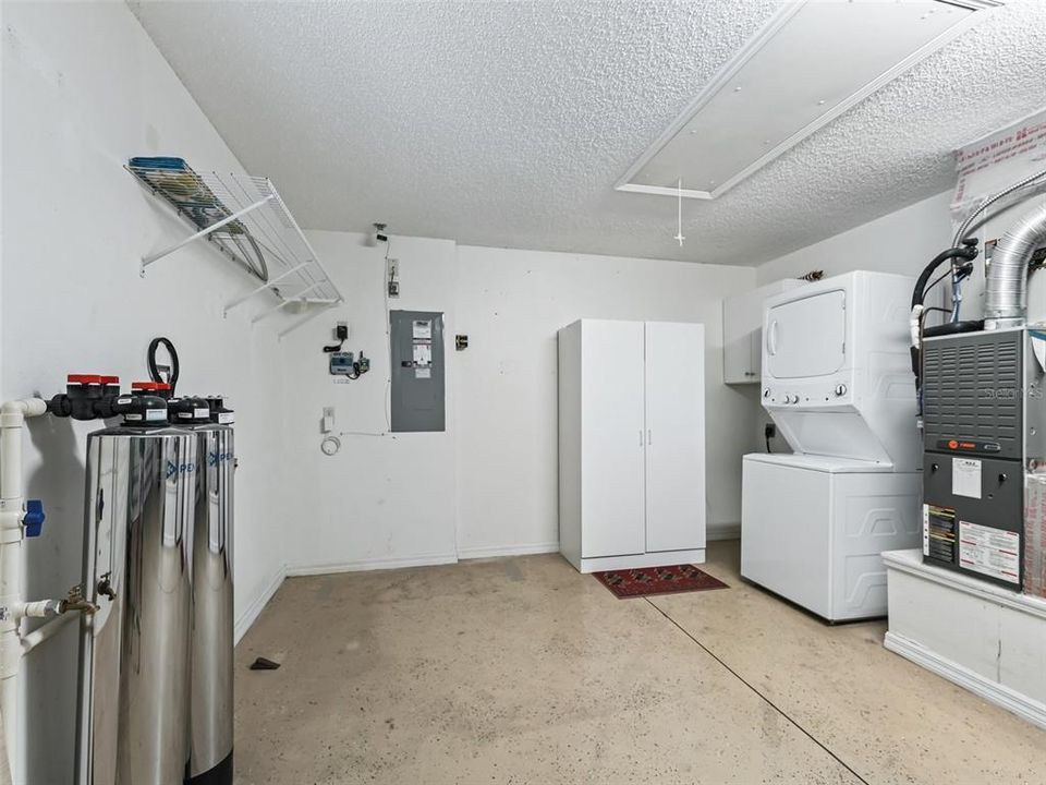 Garage with Water Filtration System, Painted Garage Floor, Cabinetry and Stackable Washer and Dryer