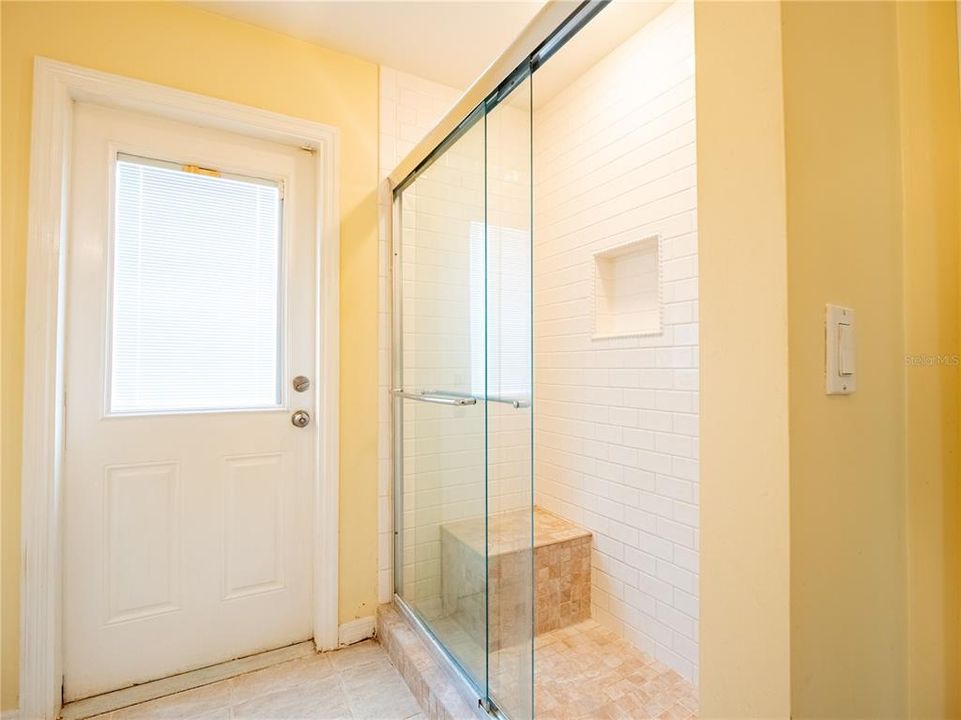 Large Guest Shower with Glass Sliders and Sitting Stone