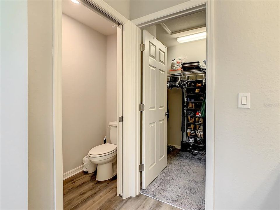 Private toilet room and peeking into a massive walk in closet.