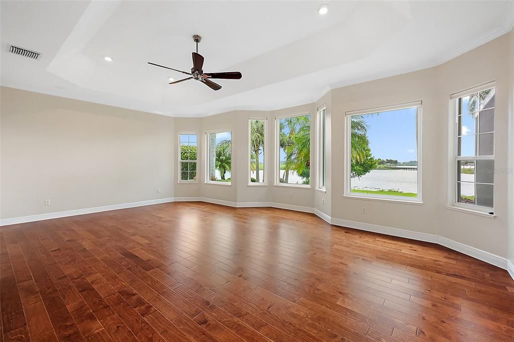 Master bedroom w/wood flooring & tray ceiling