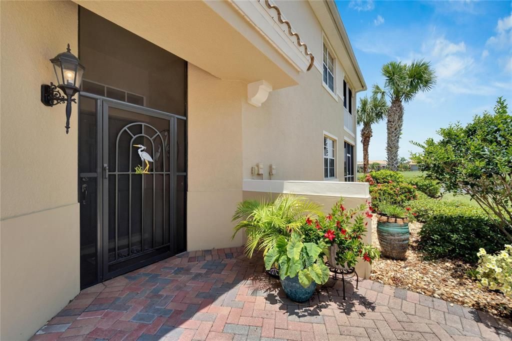 Walk up to this screened in covered front entrance doorway and you get the Florida "feeling" with lush greenery and beautiful landscaping.