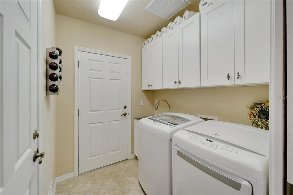 Laundry room leading out to the two car garage has LOTS of storage, utility sink and good lighting. The white cabinetry offer a very nice touch. Washer and Dryer included, but will be replaced with new units.