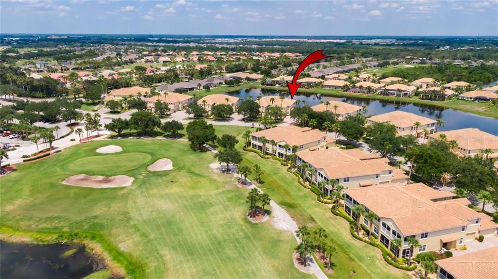 Community aerial view of the condo unit highlighted with a red arrow.