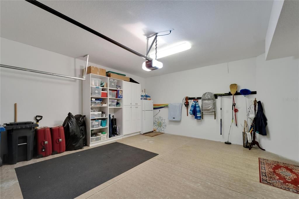 Two car garage with shelving and ample storage has been upgraded.