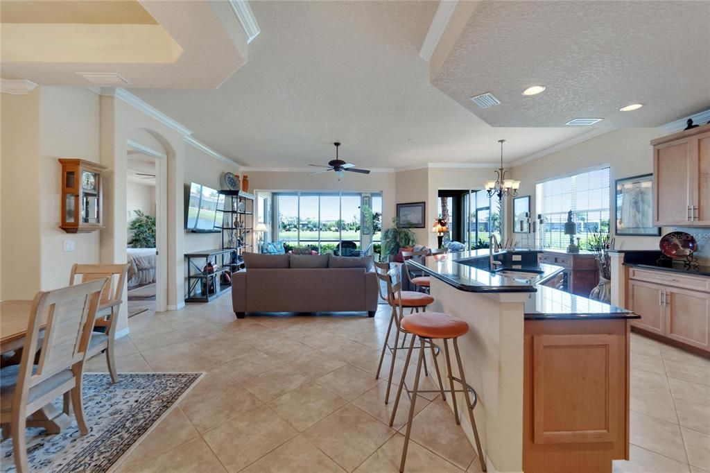 An open floor plan overlooks the living area and eat in dinette with a fabulous water view. Notice the kitchen island is a multi level bar that offers as both a counter for the sink and extra cooking space, as well as a sit up bar area to eat at, if desired.