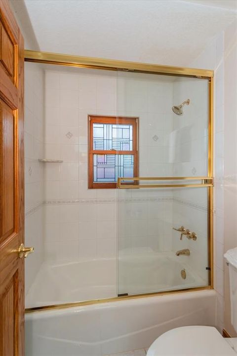 Tub/Shower combination in Guest Bath - brass fixtures.