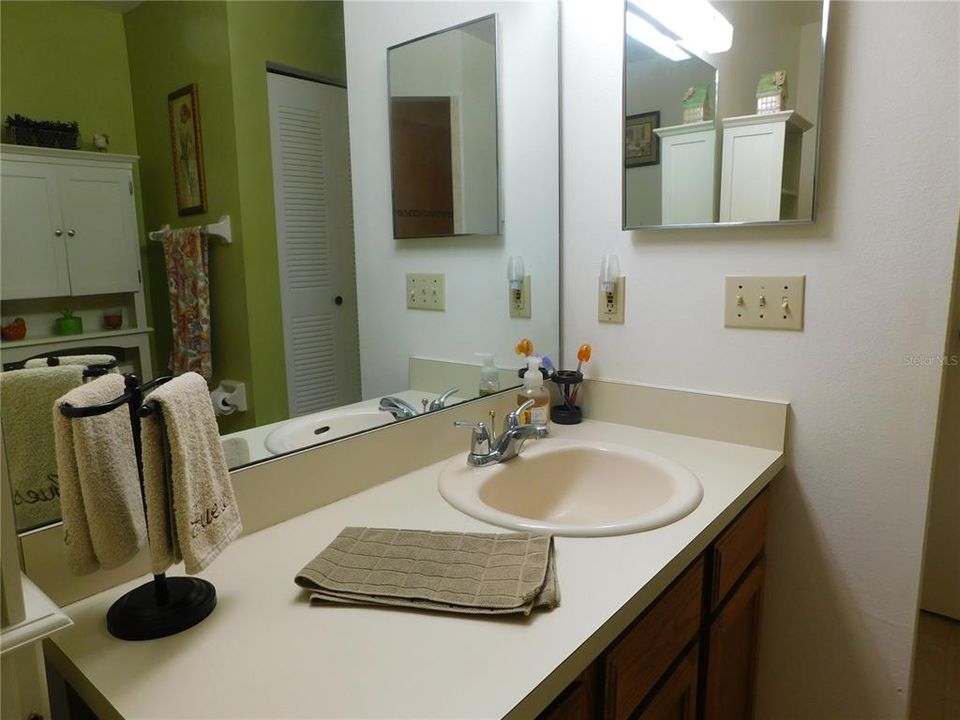 Large vanity with one sink and ample storage below, medicine cabinet.