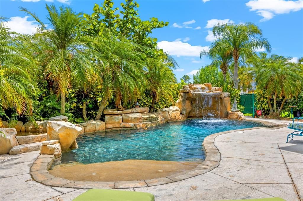 heated Saltwater Pool has a grotto, waterfall, custom hot tub, color changing lights, and outdoor shower.
