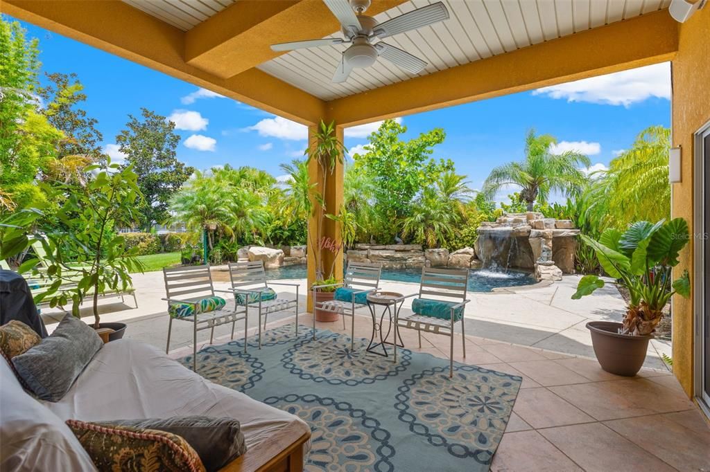 Covered lanai. The backyard and pool are surrounded by mature landscaping