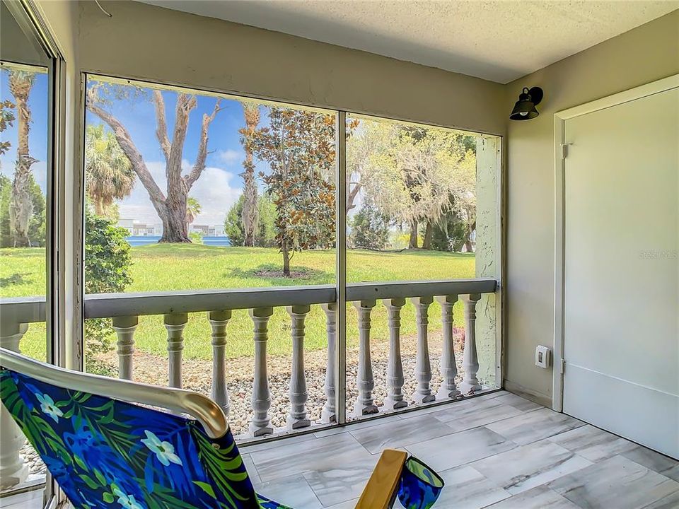 screened-in lanai adorned with complementary tile flooring. Savor a cup of coffee on breezy mornings or relax on tranquil afternoons or evenings as you unwind while relishing the picturesque views of the meticulously maintained grounds