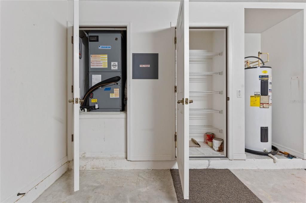 Garage storage closet with shelves, A/C Handler, Hot Water Heater and Riser.