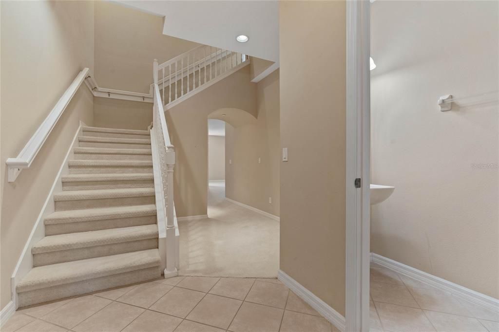 Stairs from Foyer leading to upstairs Bedrooms. Powder Room to the Right.