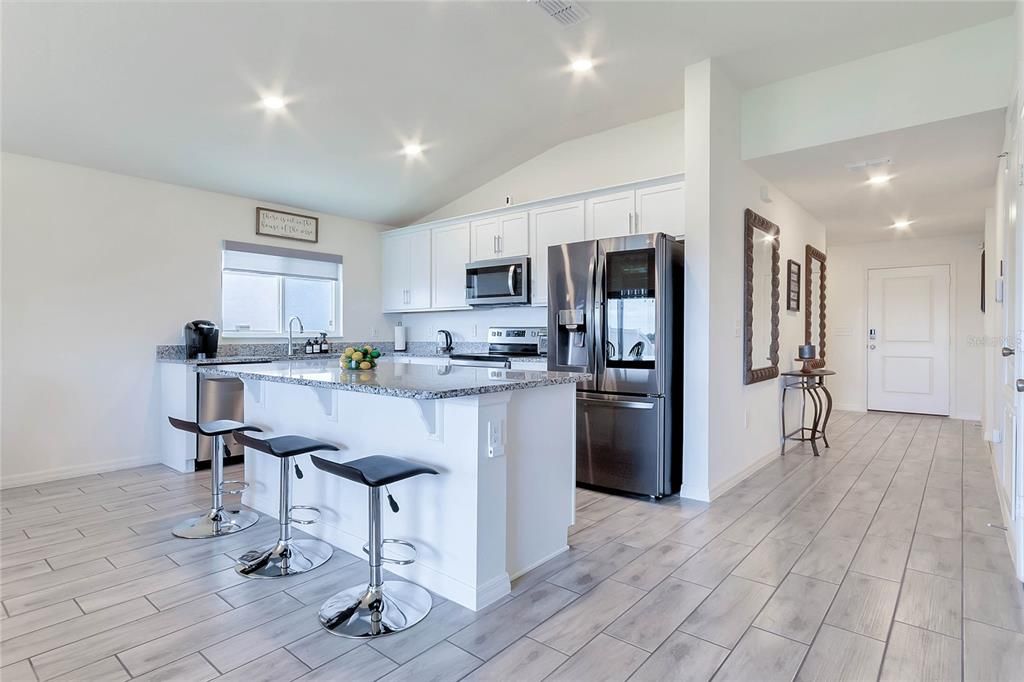 As you step inside, you'll be greeted by wood tile floors that run throughout the living areas and baths, providing a stylish and low-maintenance flooring option.