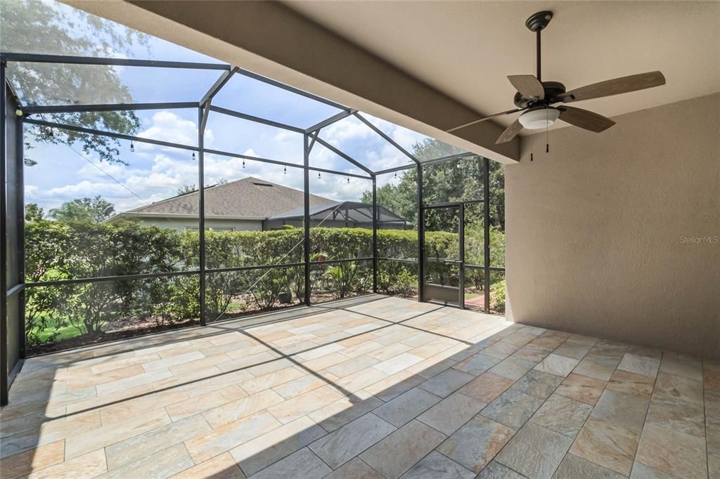 COVERED PORCH/LANAI: UPGRADED, EXTENDED AND SCREENED-IN, SLATE LOOK TILE, MATURE LANDSCAPING HEDGE FOR PRIVACY