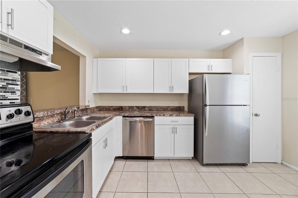 The kitchen has been thoughtfully updated with **NEWER CABINETS** providing ample storage space for all your culinary needs!