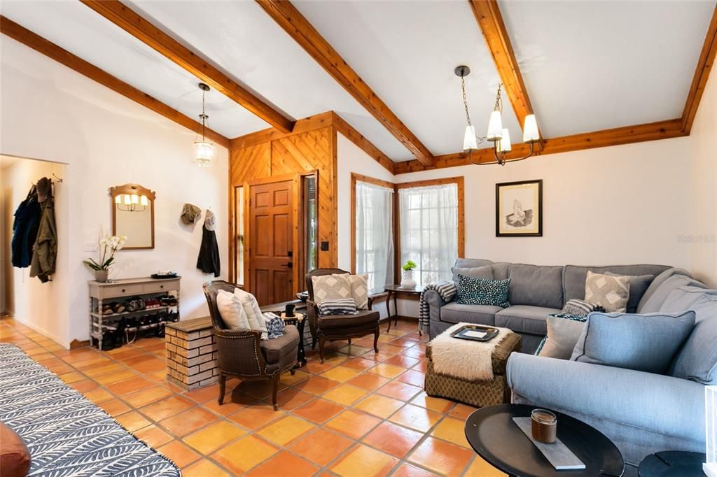 Upon entry, you'll find a living room space with stunning vaulted ceilings that showcase exposed wood beams.