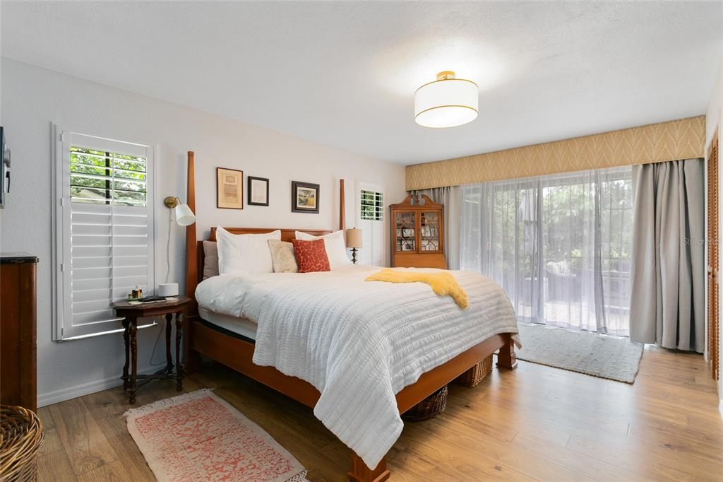 The master bedroom offers private pool access, plantation shutters, and a walk-in closet.