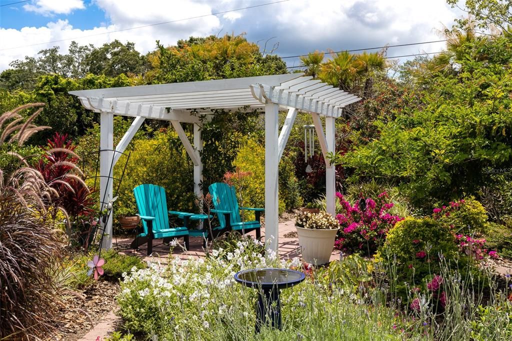 The gardens at this home are the owners PRIDE and JOY!    This pergola will be a wonderful place to relax and watch the Butterflies and Birds enjoying all of the plants and flowers!