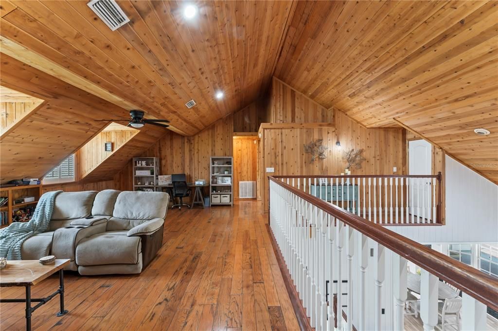 Upstairs loft with original hardwood flooring and cedar boards ceiling