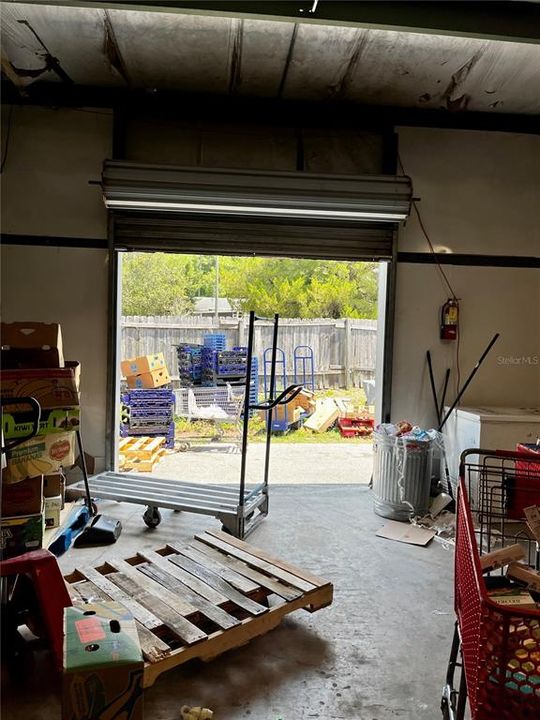 View from mid-warehouse of bay electric roll up door looking toward right rear fence line.Entry to store on the right.