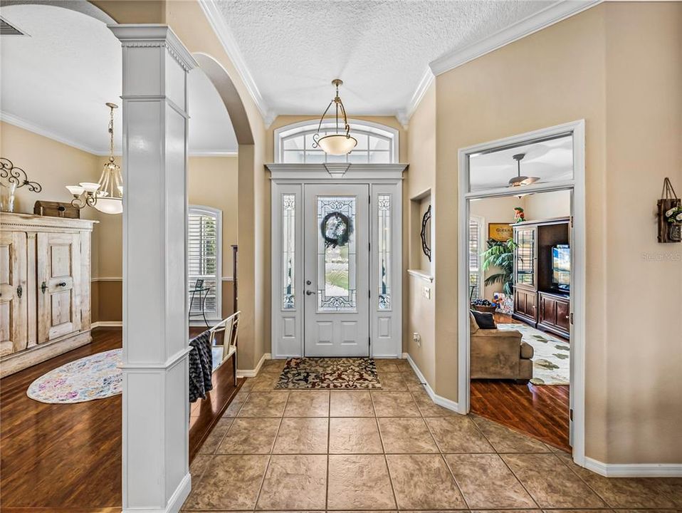 Entry foyer. Notice crown molding, transom windows and decorative columns.