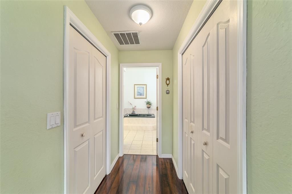 Entry to master bath with closets on both sides