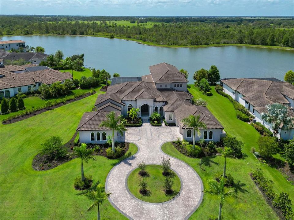 This home will capture your heart. Circular drive for parking, 4 garages with charging stations, and lovely lake views on 1.5 acres