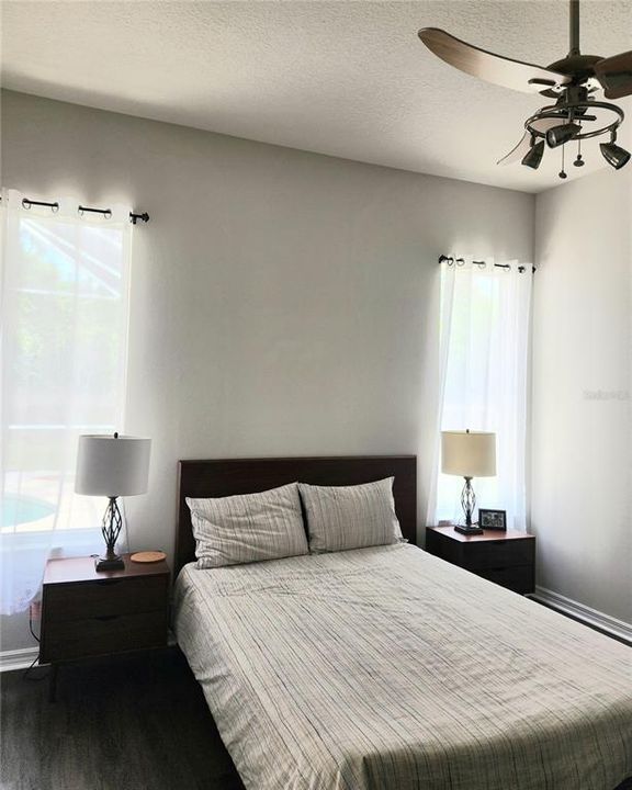 Primary bedroom with walk in closet and sliders to pool area