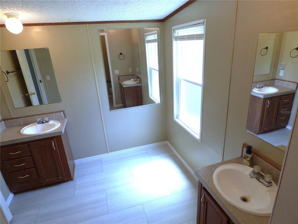 Master bathroom with dual sinks and corner space w/capped pipes ready for tub install