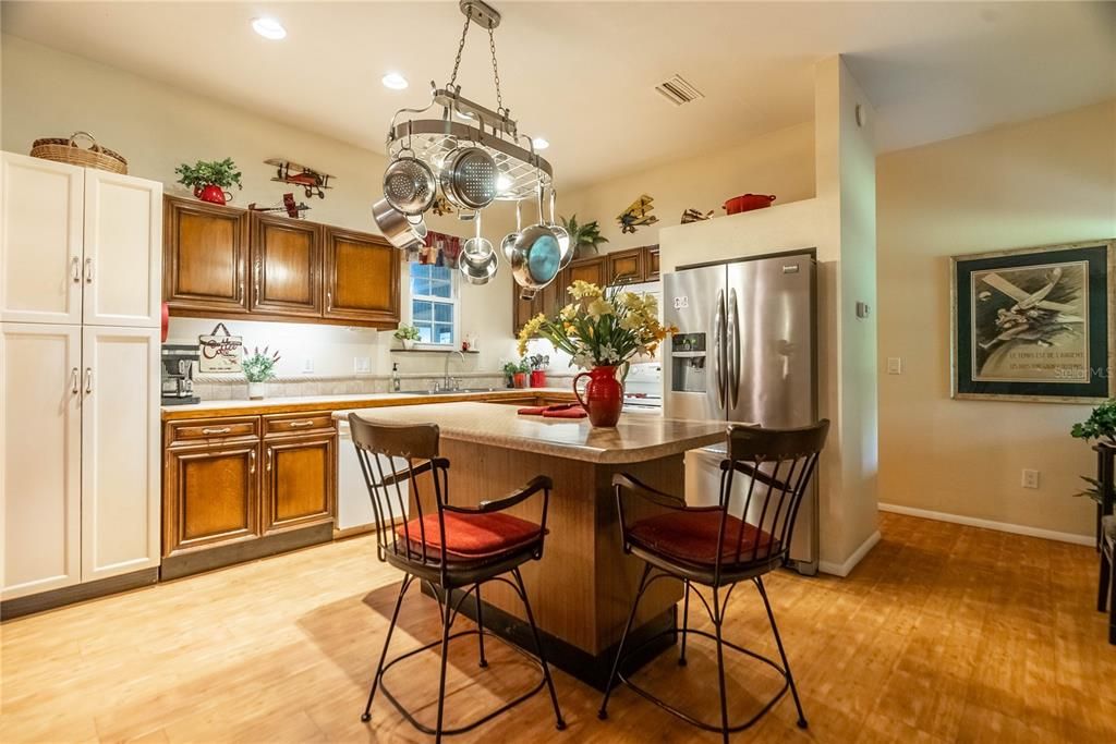 The kitchen is nice and bright with recessed lights. Behind the wall of the frig is the short hall way leading to the master bedroom, bathroom, utility and exit to the hangar.
